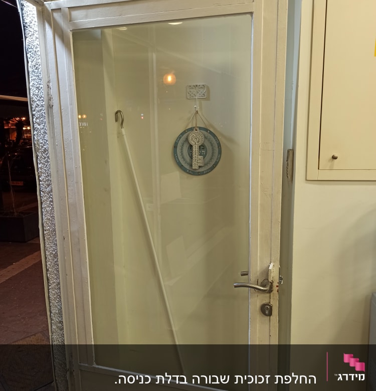 דלת זכוכית עם ידית מתכת ותליון עגול